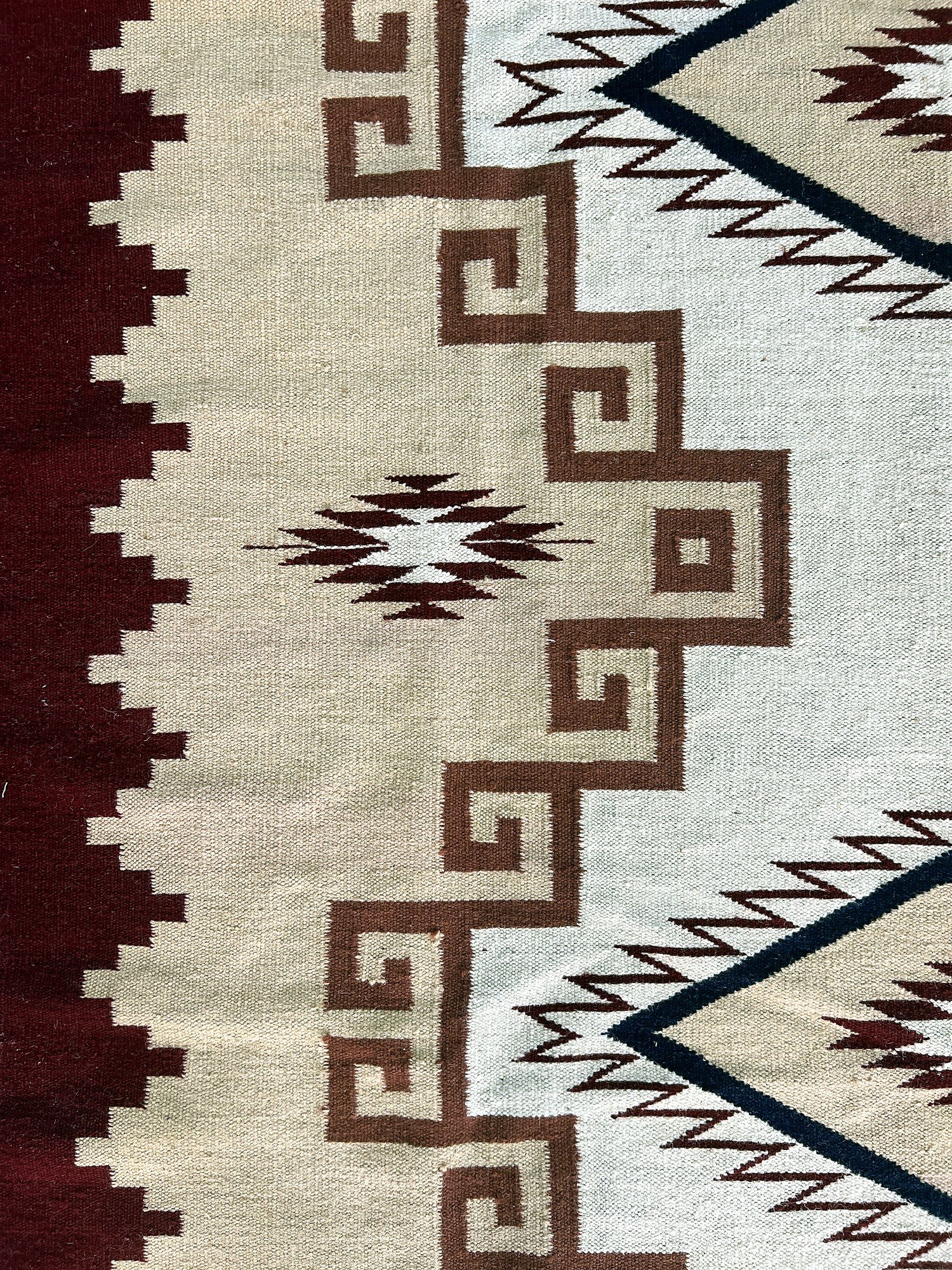Close-up of the maroon border and fringe on the ivory diamond medallion kilim rug | The Rugs Curator — Pakistani Premium Rugs