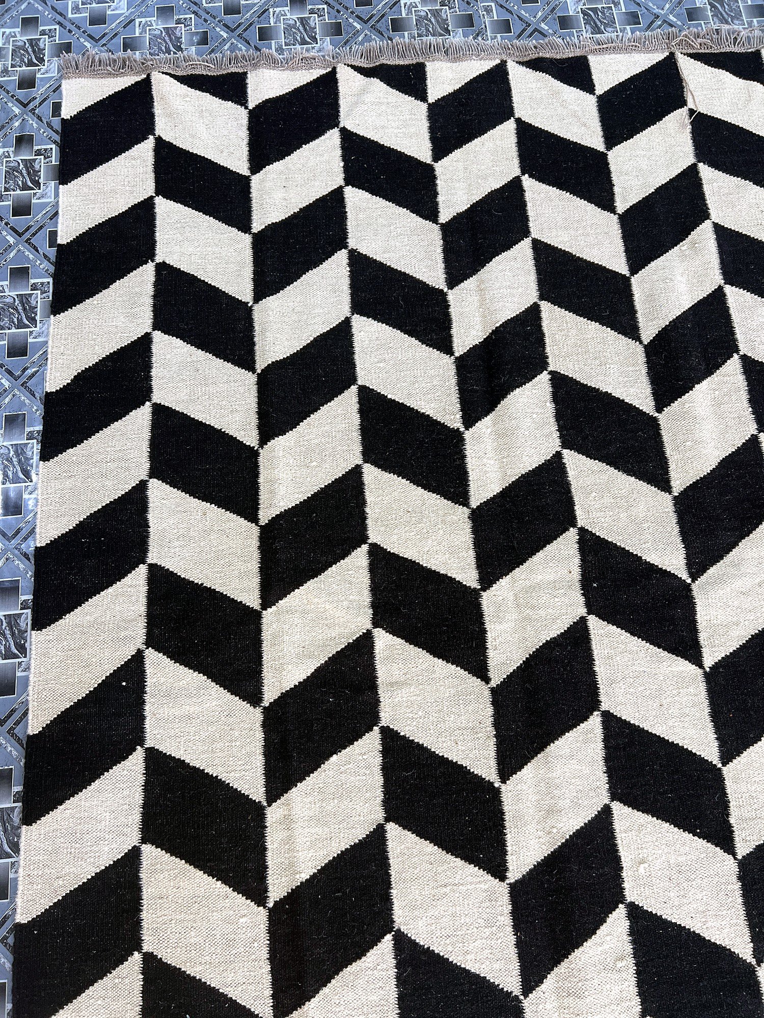 Close-up of the herringbone weave texture on the black and ivory chevron kilim rug | The Rugs Curator — Pakistani Premium Rugs
