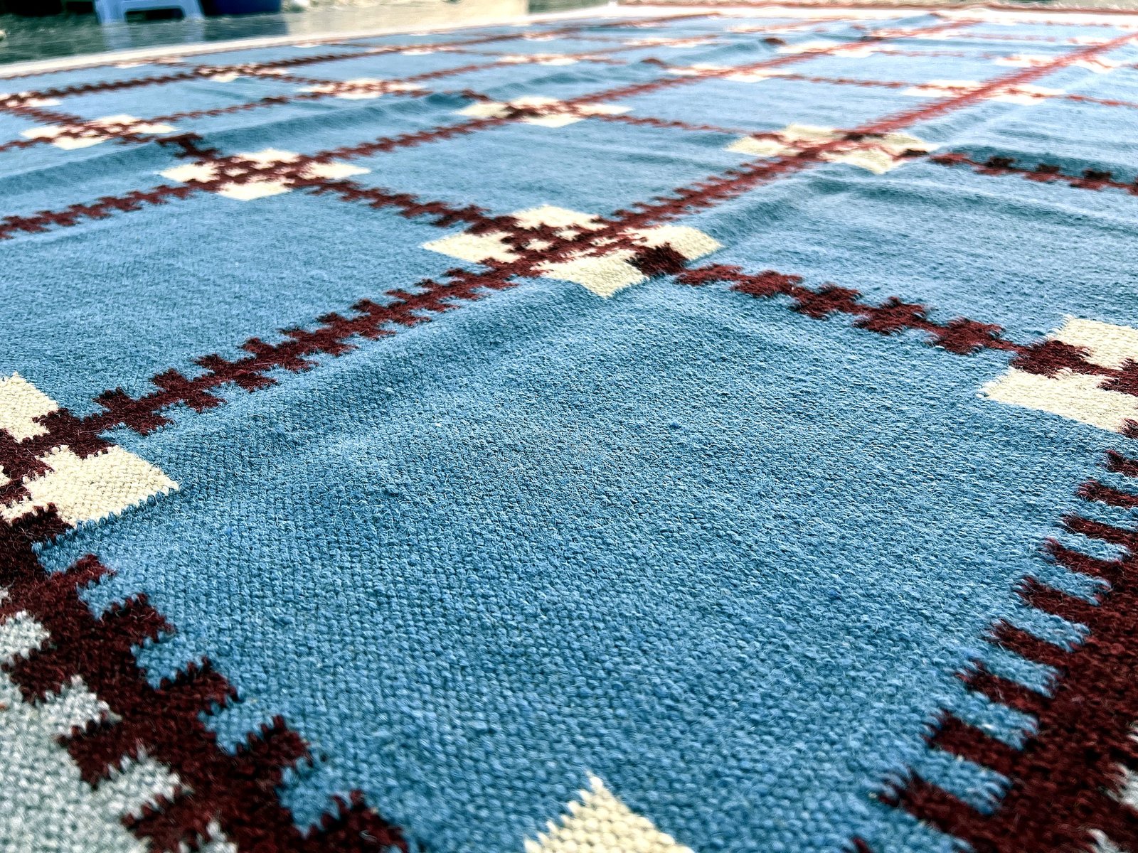 Close-up of the flatweave texture on the cobalt blue kilim rug with maroon grid pattern | The Rugs Curator — Pakistani Premium Rugs