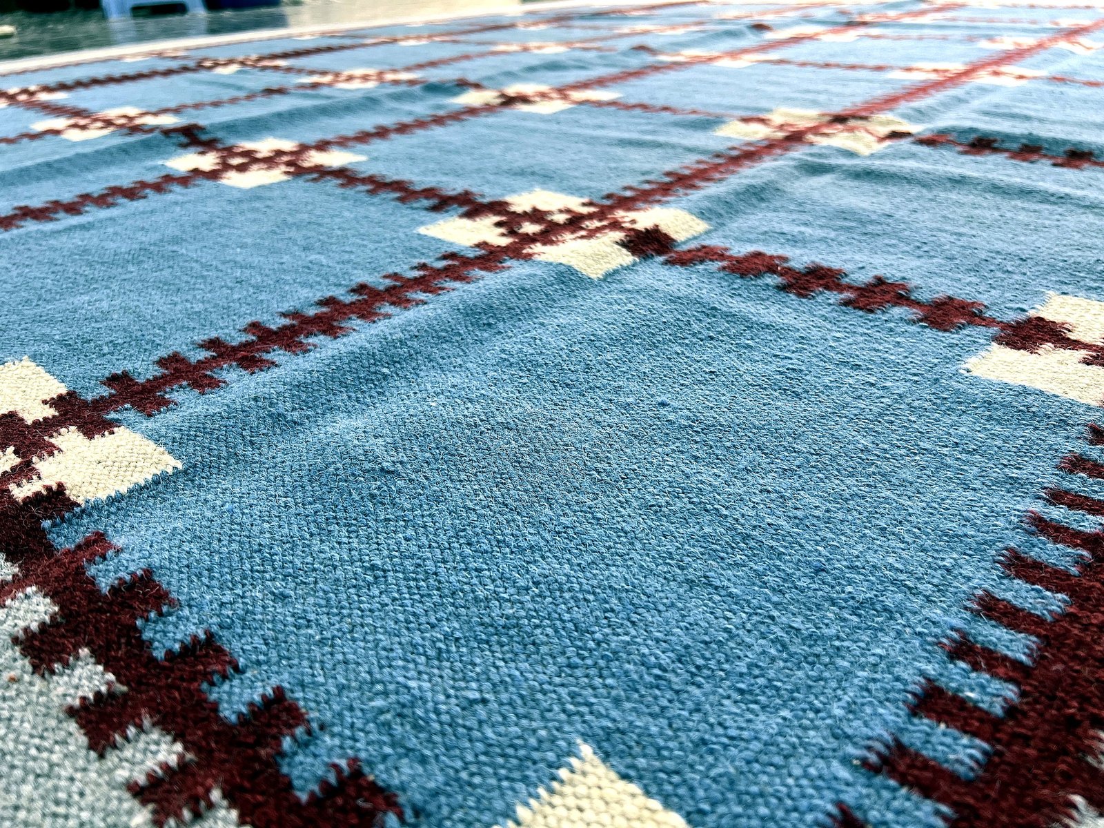 Close-up of the woven fringe and grid pattern on the cobalt blue kilim rug | The Rugs Curator — Pakistani Premium Rugs