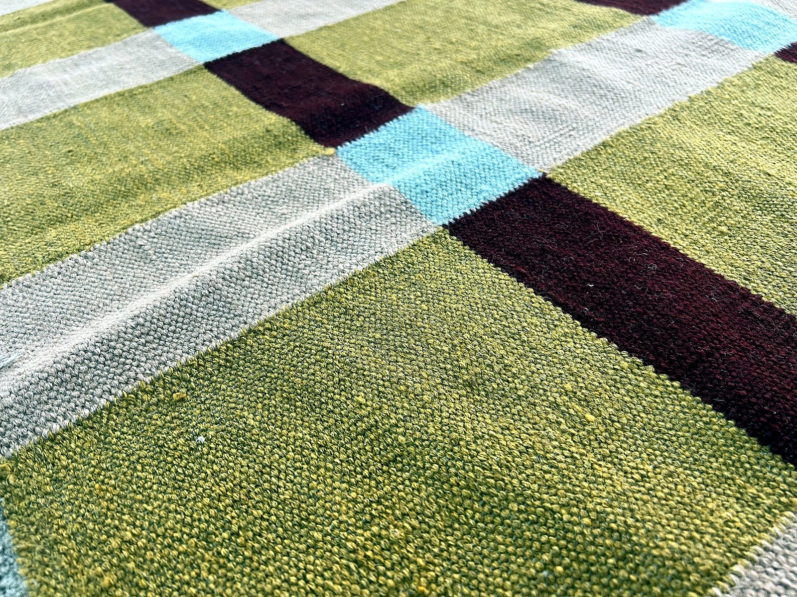 Close-up of the windowpane check pattern and fringe on the mustard kilim rug | The Rugs Curator — Pakistani Premium Rugs