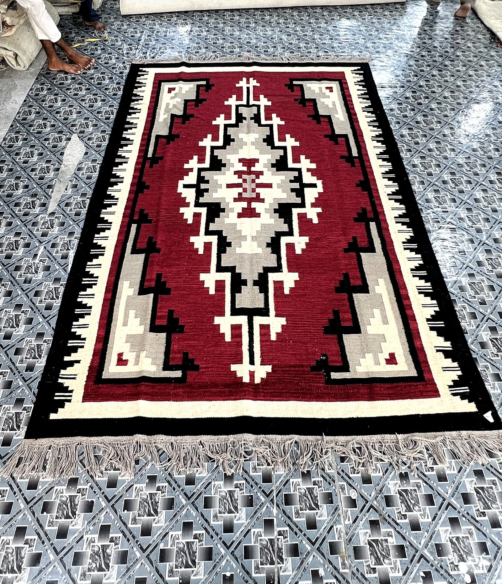 Angled full-length view of the handwoven crimson red kilim rug with grey and ivory medallion | The Rugs Curator — Pakistani Premium Rugs