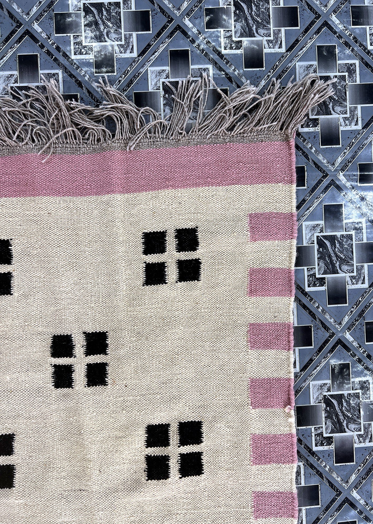 Close-up of the pink border and fringe on the ivory confetti dot kilim rug | The Rugs Curator — Pakistani Premium Rugs