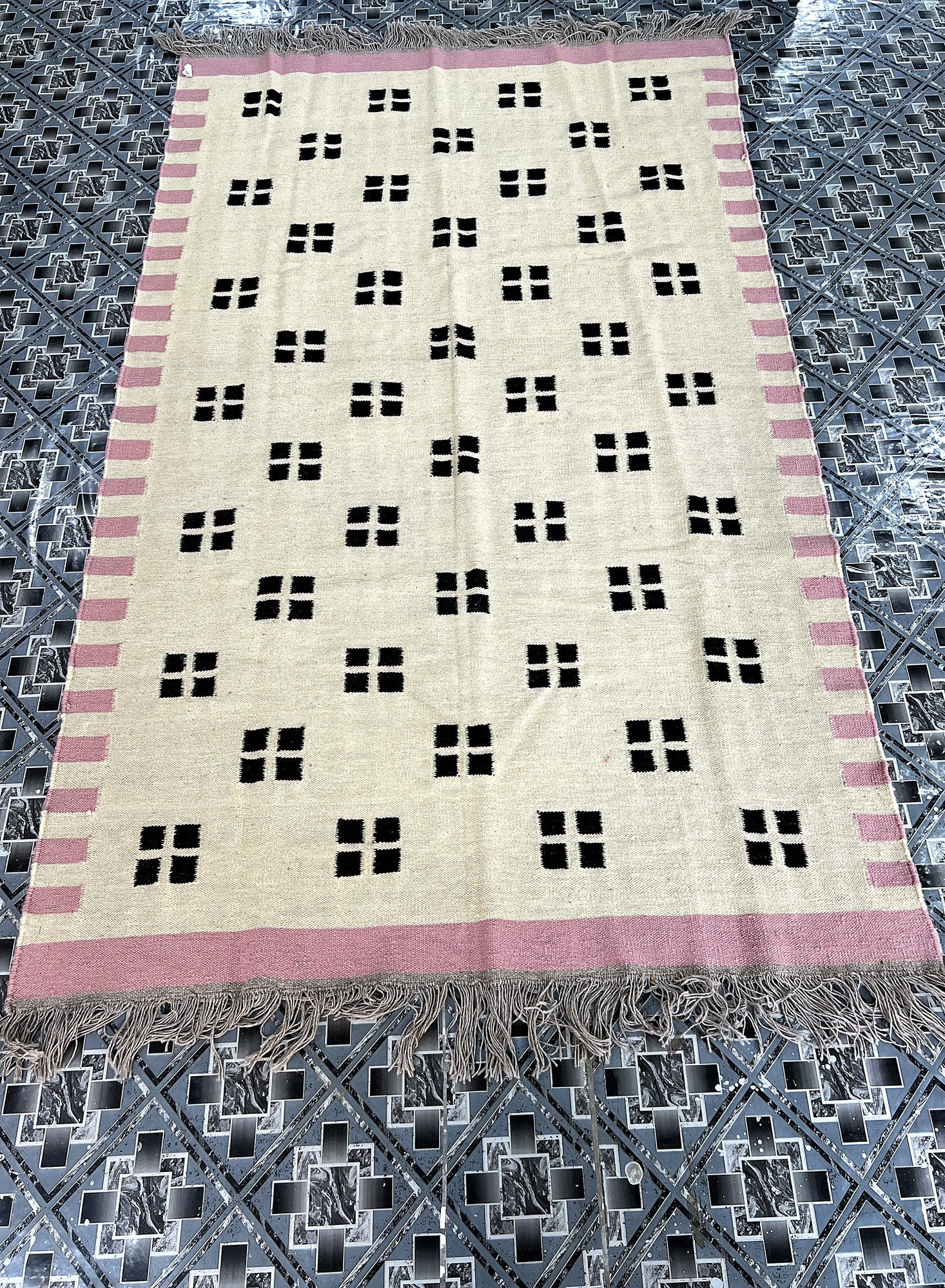 Handwoven ivory kilim rug with black confetti dot pattern and pink border | The Rugs Curator — Pakistani Premium Rugs
