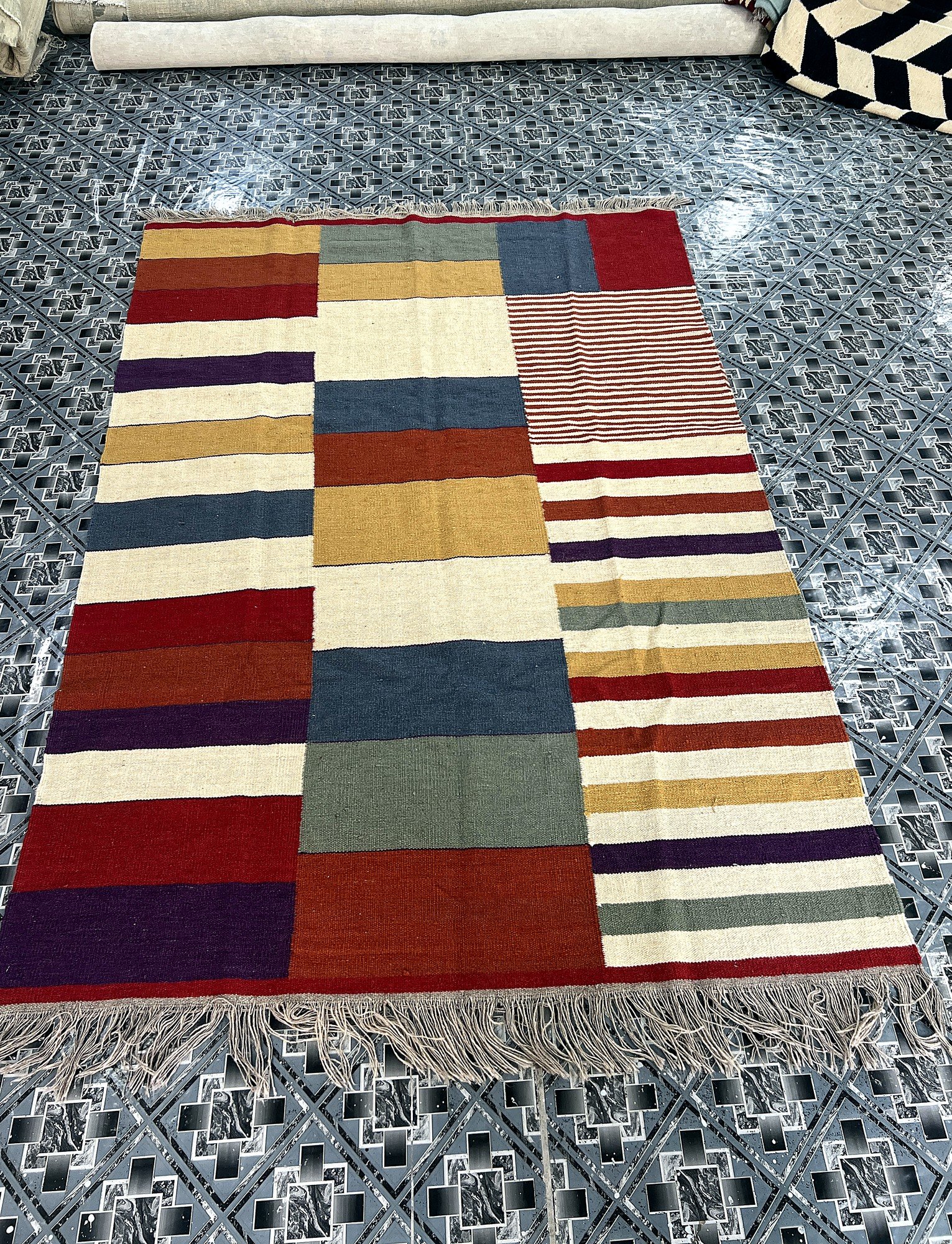 Angled full-length view of the handwoven multicolor patchwork kilim rug with striped panel, shown on the floor with fringe edge | The Rugs Curator — Pakistani Premium Rugs