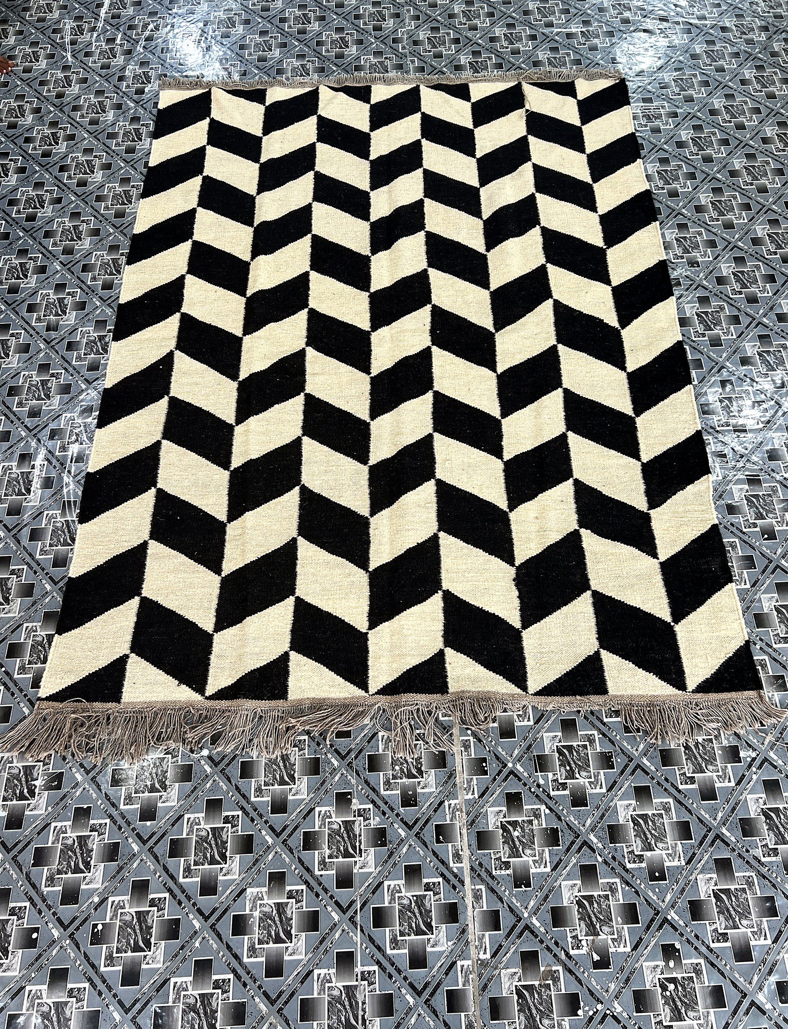 Angled full-length view of the handwoven black and ivory chevron herringbone kilim rug | The Rugs Curator — Pakistani Premium Rugs